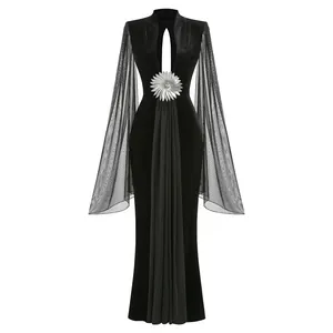 Vestido de noche negro con mangas de campana de malla y broche de flor plateada, vista frontal