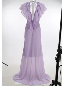 Back view detail of a lilac backless evening dress with ruffles and high waist design.