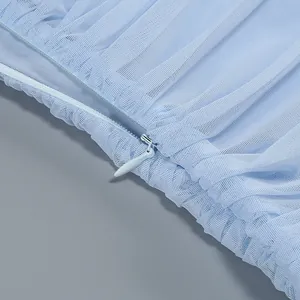 Close-up detail of the matching blue invisible zipper on a pleated mesh fabric dress