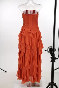 Detalle posterior de un elegante vestido largo de gasa naranja sin tirantes en maniquí.