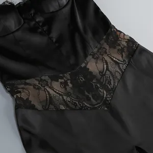 Close-up detail showing exquisite floral lace patchwork on a sleek black satin dress