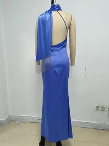 Detalle posterior de vestido maxi azul sin espalda con fajín de flecos elegante