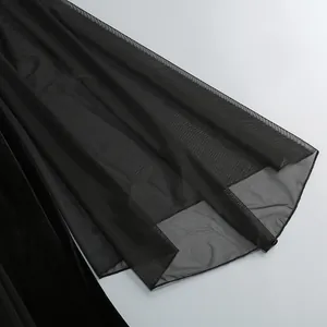 Primer plano del detalle de la manga de malla negra transparente de un elegante vestido de gala