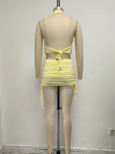 Vista posterior de un minivestido ajustado fruncido con espalda descubierta en amarillo