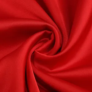 Primer plano macro de tela de satén rojo vibrante con textura de seda lisa y brillo