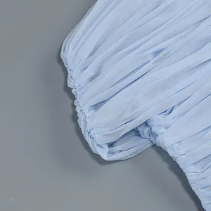 Macro detail showing the delicate pleated light blue mesh fabric of this evening dress