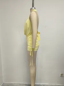 Vista lateral detallada del minivestido amarillo con cuello halter y detalle fruncido