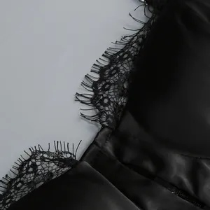 Detailed macro view showing the delicate eyelash lace trim on a black satin slip dress