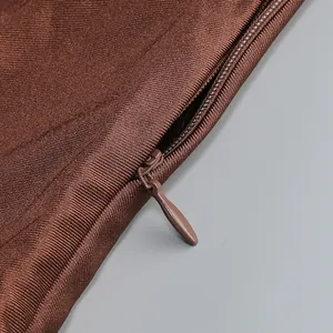 Primer plano de una cremallera invisible en un vestido ajustado de punto marrón elegante.