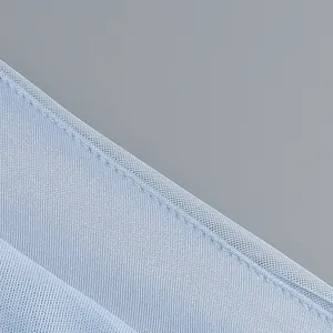 Close-up detail of light blue mesh fabric seam on elegant evening maxi dress.
