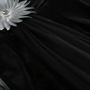 Detalle de una flor de pedrería plateada en tejido de gasa y terciopelo de vestido