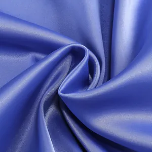 Vista macro de la lujosa textura de la tela de satén azul real para un vestido de noche