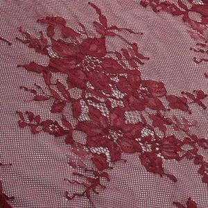 Detailed close-up of intricate burgundy floral lace fabric showing fine mesh textures