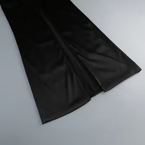 Detail view of an elegant black satin dress hem featuring a stylish side slit design