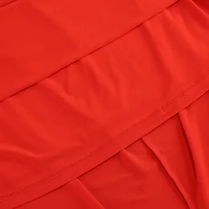 Primer plano de las costuras finas y la textura de la tela roja vibrante de un vestido.