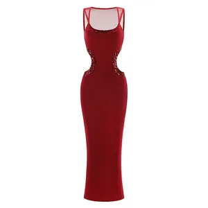 Detalle de un vestido largo rojo ajustado con aberturas sexys y bordes de lentejuelas brillantes.