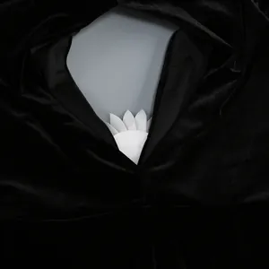 Primer plano detallado del elegante vestido de terciopelo negro con acento de pétalo blanco