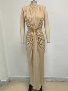 Detalle de un elegante vestido largo beige sin mangas con cuello alto y abertura en la cintura