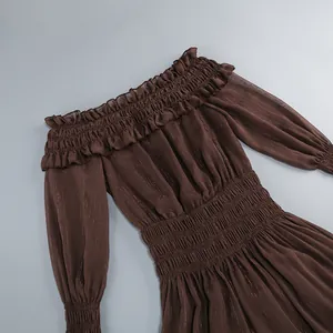 Detalle de vestido marrón con hombros descubiertos, volantes y cintura elástica