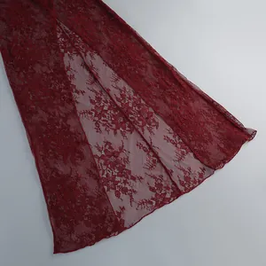 Detailed close-up view of wine red floral lace fabric featuring a stylish high slit design
