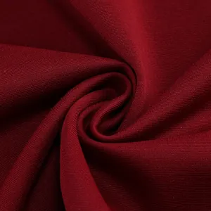 Primer plano de la tela del vestido burdeos que muestra la fina textura de punto y caída.
