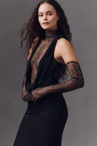 Close-up of an elegant black halter neck dress featuring intricate lace patchwork details