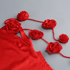 Primer plano de vestido de satén rojo con tirantes de flores rosas 3D artesanales