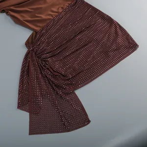Detalle de diamantes de imitación brillantes en un minivestido sexy marrón con cortes