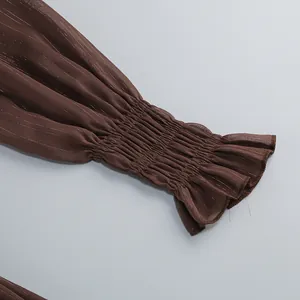 Detalle macro de cerca del puño elástico fruncido con volantes en un vestido marrón