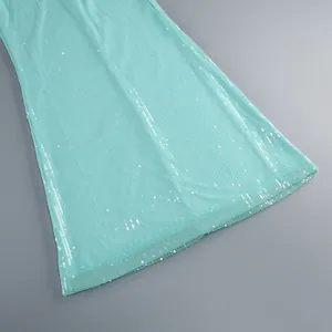 Primer plano detallado de las lentejuelas turquesas brillantes de un maxi vestido de verano