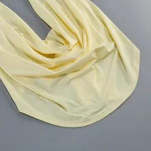 Detalle del vestido halter amarillo claro que muestra la caída de tela y dobladillo.