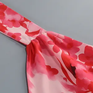 Primer plano de tela con estampado floral rosa y pliegues en un vestido de verano.