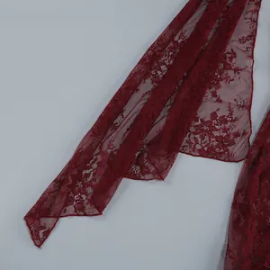 Detailed macro view showing the intricate burgundy red floral lace fabric texture