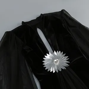 Vista detallada de un elegante vestido de noche de terciopelo negro con mangas de malla