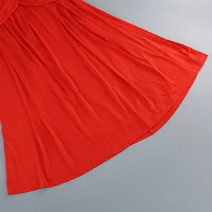 Detalle macro de una falda larga roja brillante estilo vacaciones con dobladillo liso.