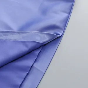 Detalle macro de la suave tela de satén y el dobladillo del vestido largo de lavanda.