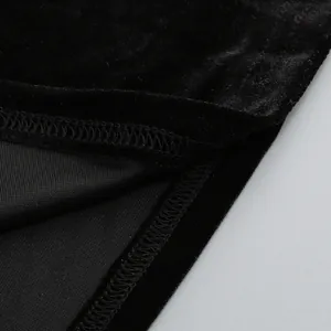 Primer plano detallado de la costura overlock y la tela de terciopelo negro del vestido.