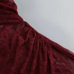 Detailed close-up of elegant burgundy floral lace fabric with delicate mesh texture