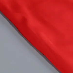 Vista macro de la textura de la tela roja lisa de alta calidad para un vestido largo elegante.
