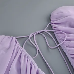 Close-up detail of purple chiffon dress showing elegant lace-up back and pleats