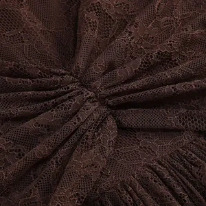 Macro detail of high-quality brown floral lace fabric showing elegant pleated texture