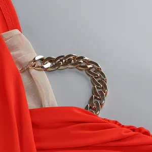 Detalle de un vestido rojo sexy con cadena dorada y panel de malla transparente