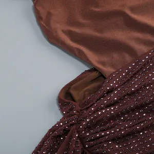 Primer plano de pedrería brillante sobre el tejido de malla marrón de un vestido