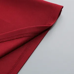 Primer plano de las costuras del dobladillo y la textura del tejido granate de este vestido largo.