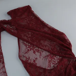 Close-up of intricate burgundy floral lace fabric on a long dress detail