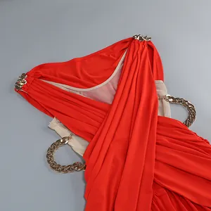 Detalle de un vestido rojo de vacaciones con cadenas doradas y diseño cruzado