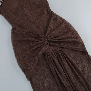 Close-up of brown hollow-out lace fabric and elegant pleated waist detail on party gown