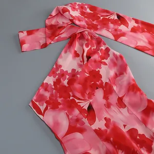Detalle de un vestido de verano con flores rojas y un elegante cuello de bufanda.