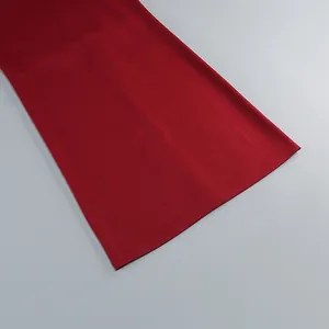 Detalle del dobladillo de un vestido rojo oscuro que muestra la tela de calidad y la costura