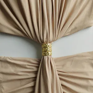 Detalle de los anillos dorados en el recorte de la cintura de este elegante vestido beige.